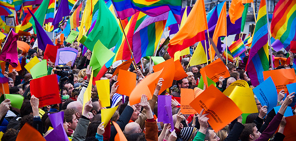foto van mensen die regenboog kleuren vasthouden op protest