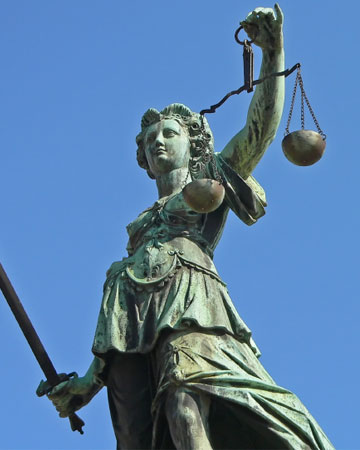 standbeeld Vrouwe justitia voor blauwe lucht