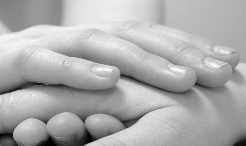 zwart wit foto van twee handen die elkaar vast houden