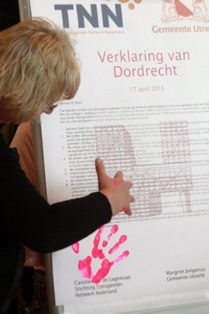 Foto van een uitvergrootte verklaring van Dordrecht met het logo van TNN en iemand die er een handafdruk op maakt.