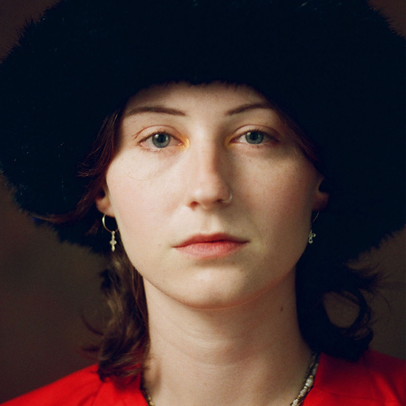 Portret van Angel met een rood shirt tegen een donkere achtergrond