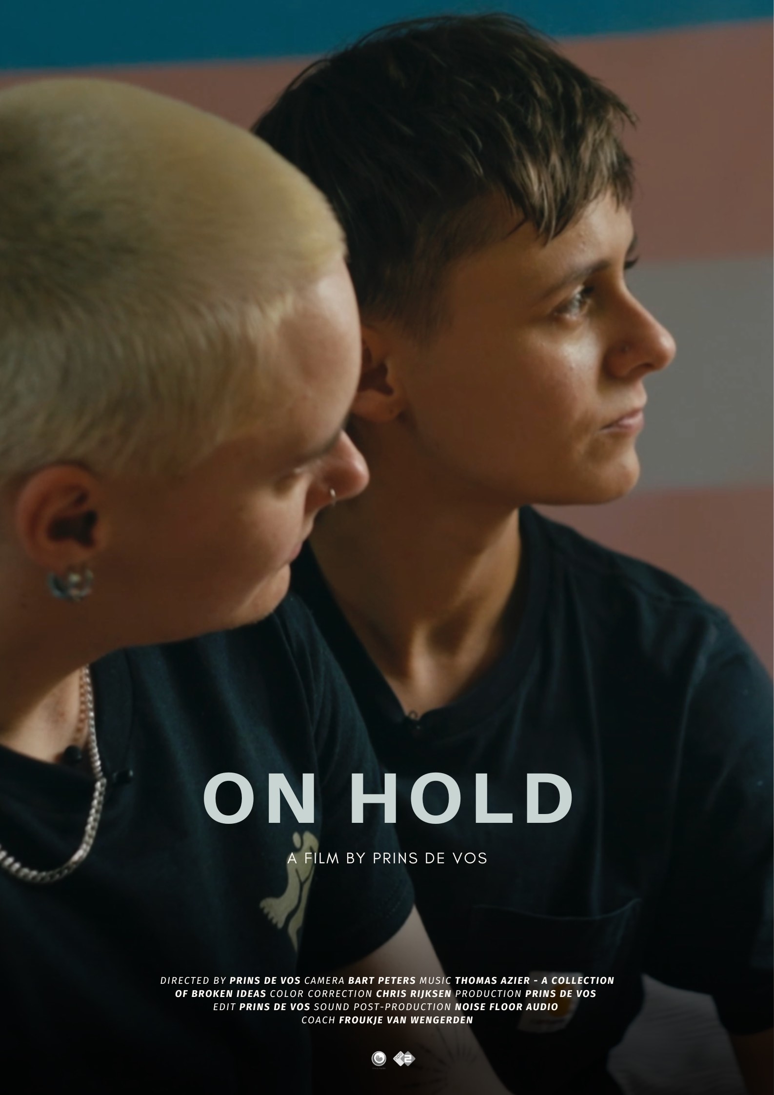 Filmposter van On Hold, een film van Prins de Vos. Twee jonge mensen zitten dicht tegen elkaar aan en kijken ernstig naar rechts, met op de achtergrond de kleuren van de trans vlag. De titel On Hold staat centraal in witte letters, met credits in kleine tekst onderaan — een intiem portret van identiteit, verbondenheid en wachttijd.